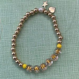 Customized 14k gold plated bracelet. Adorned w/ charms & real pearl.